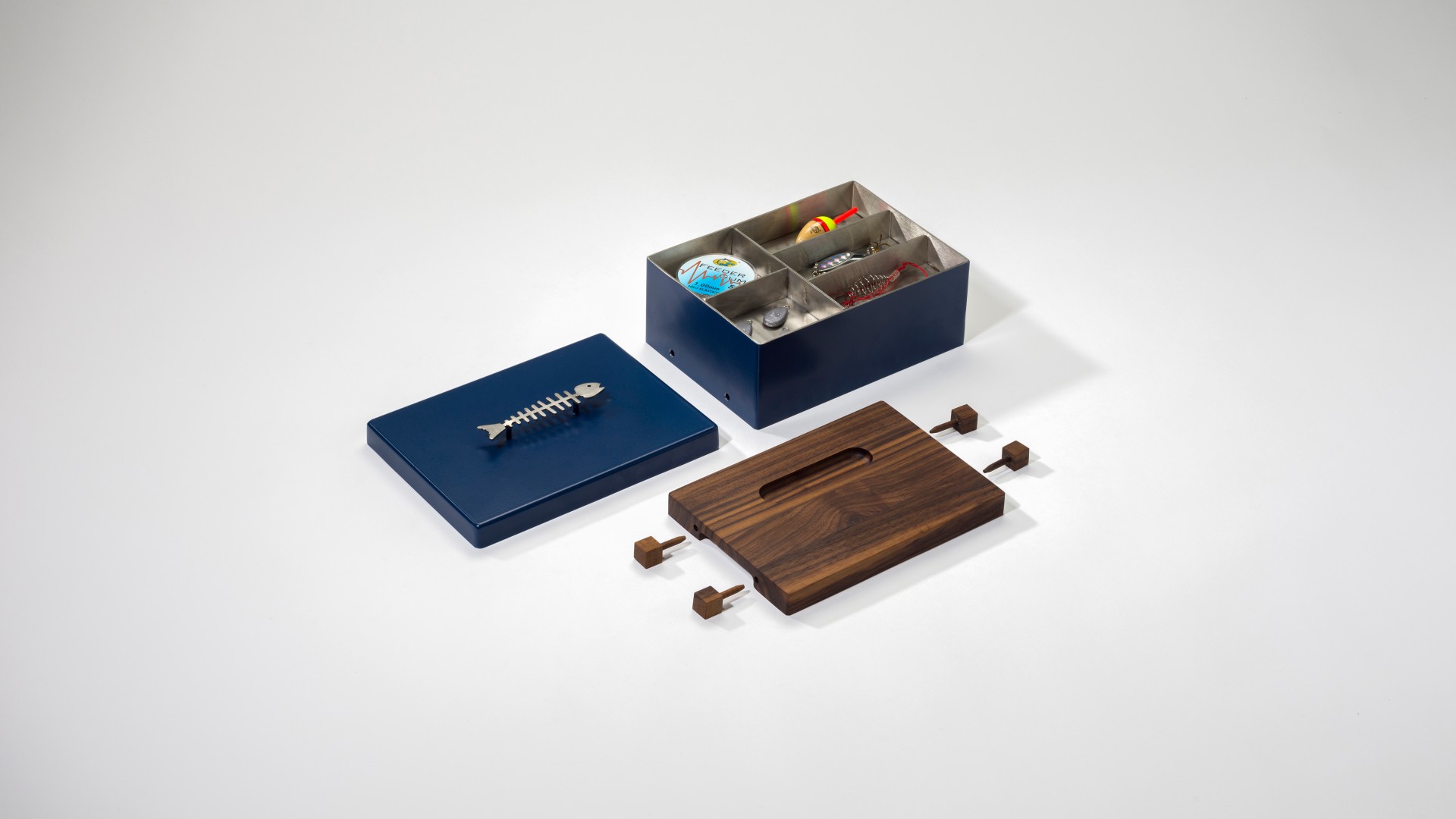 Geschlossene blaue Box aus Metall mit einem wasserstrahlgeschnittenen Grätenfisch als Henkel